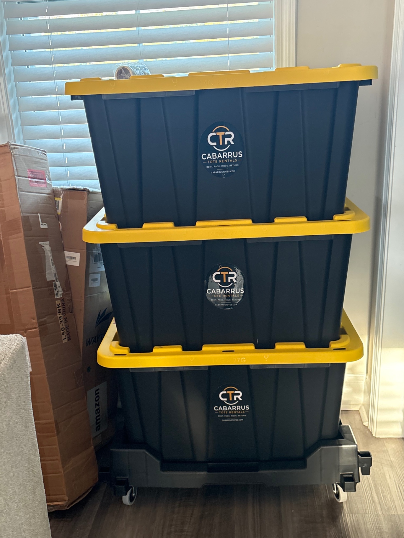 Three CTR branded 27 gallon moving totes stacked on a Tote Taxi inside a Concord NC home