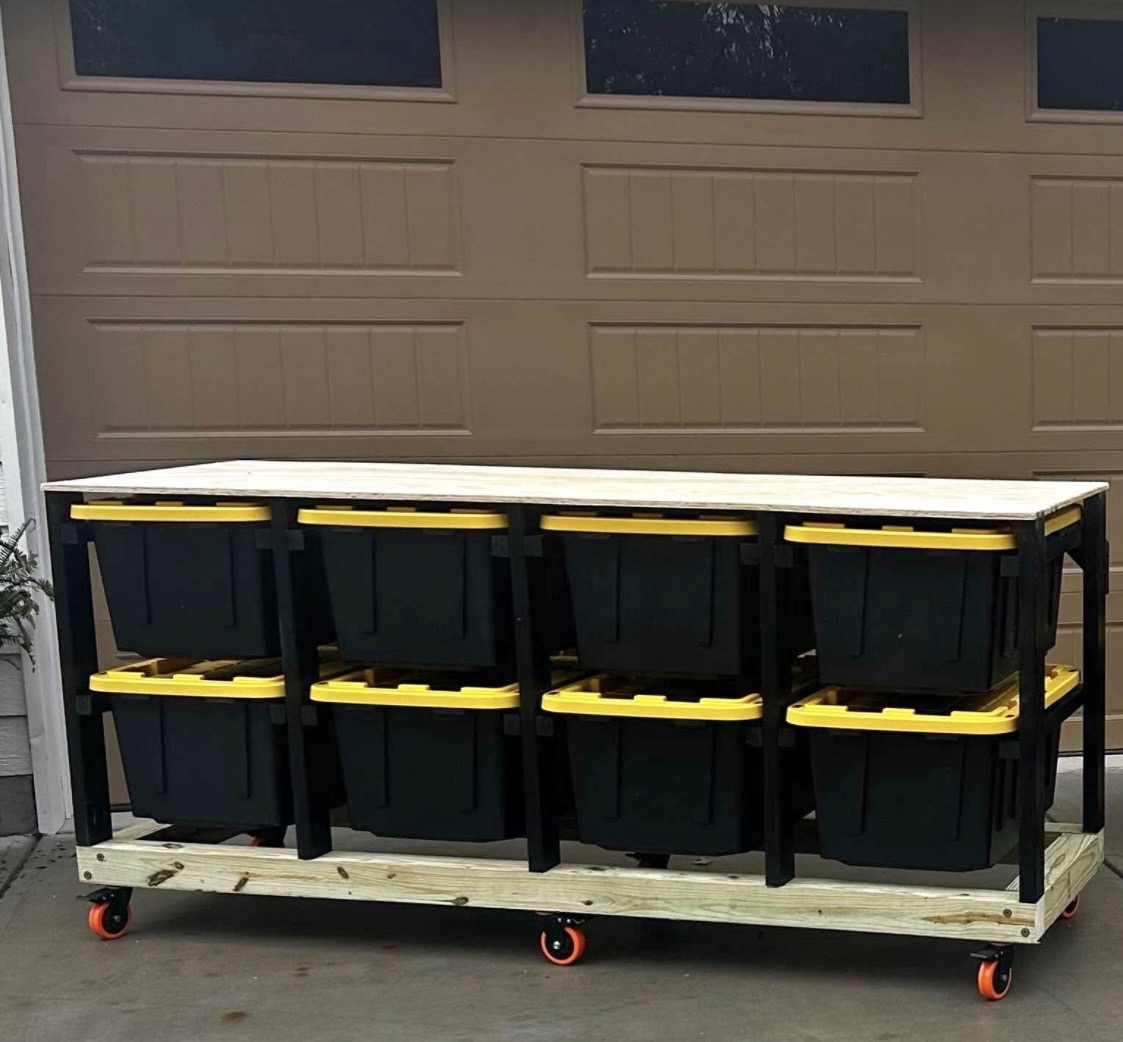 Mobile eight-tote storage station with black totes, yellow lids, a wood worktop, and locking casters