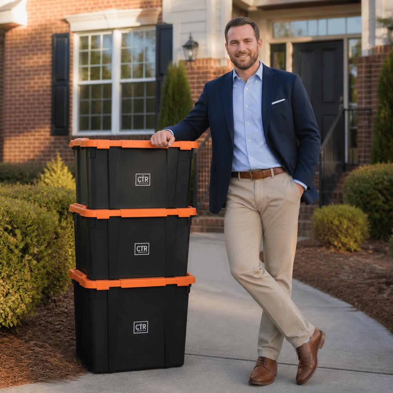 Real estate agent standing beside a stack of clean CTR-branded moving totes on the walkway of a brick home in Cabarrus County